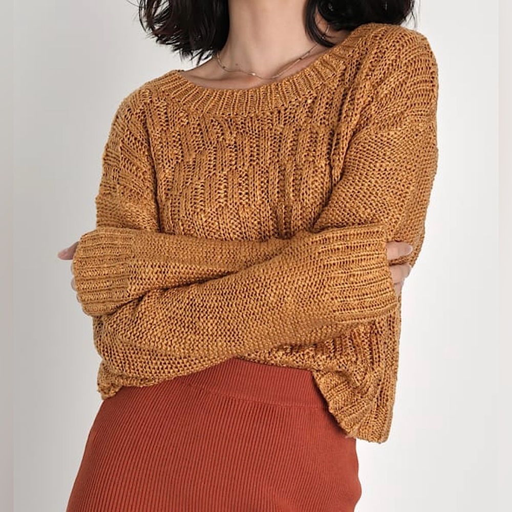An off orange/mustard colored knit sweater.